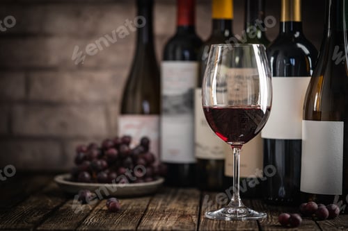 Preview: Red Wine in a Glass with Bottles and Grapes
