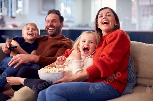 Preview: Family Sitting On Sofa With Popcorn Laughing Watching Comedy On TV Together