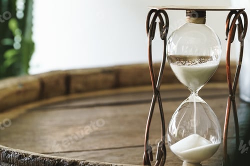 Preview: Sandglass on wooden bakground closeup. Time concept