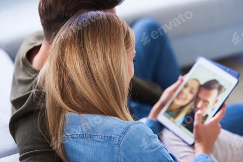 Preview: Close up of couple embracing and using a tablet