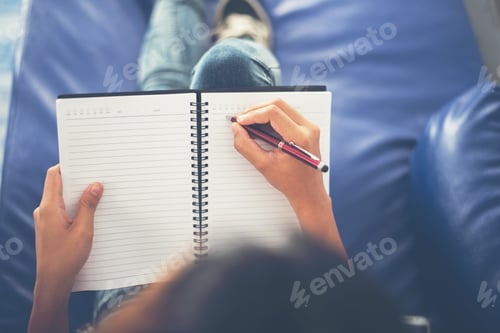 Preview: Woman hands writing on notepad lying at home .