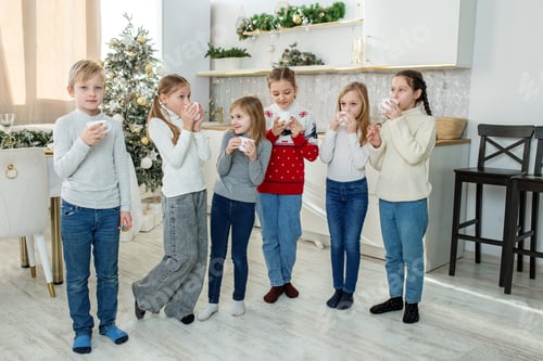 Preview: Merry Christmas and Happy Holidays. Children drinking hot chocolate at Christmas.