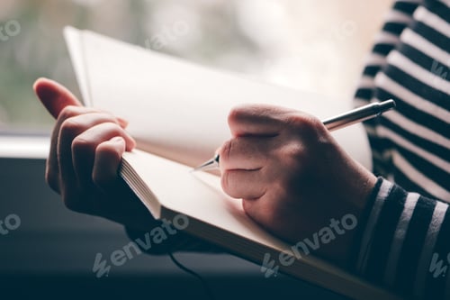 Preview: Left-handed woman writing diary