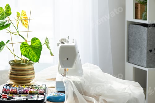 Preview: Sewing layout with multicolored spools of thread close-up, needles, electric sewing machine. Filling