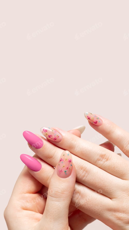 Preview: Spring manicure of woman hands with pink gel polish and dried flower design. Female hands
