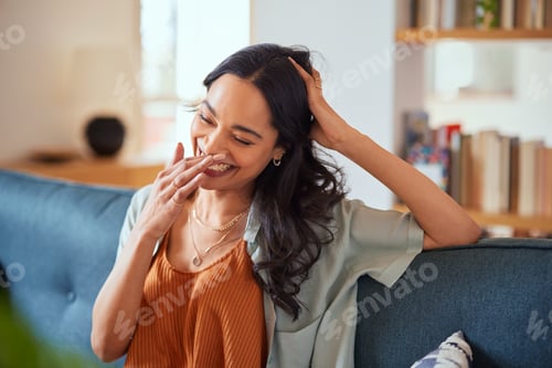 Preview: Laughing Young Woman Relaxing on Sofa Indoors
