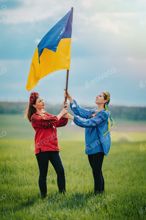 Preview: Happy ukrainian women raised national flag, it flies as symbol of love for Motherland.