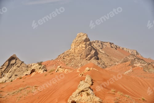 Preview: Rocky arid red sand desert mountains and rock formations in mid summer afternoon natural sunlight