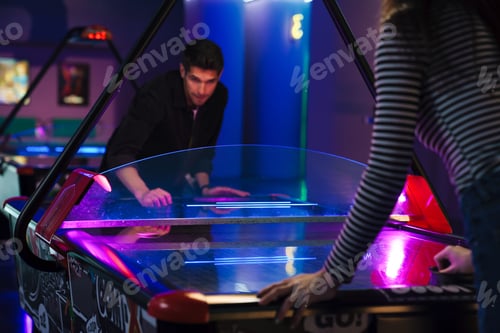 Preview: Young white man and woman playing air hockey