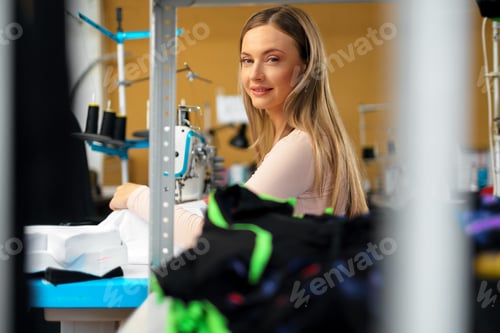 Preview: Seamstress woman at her workplace sewing clothes on sewing machine