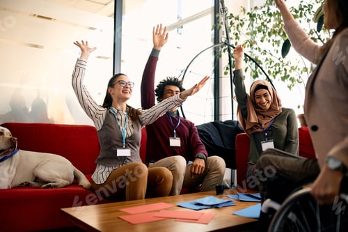 Preview: Cheerful business team with arms raised having fun at work.