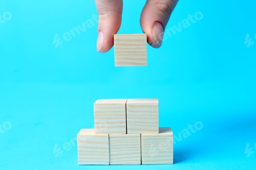 Preview: Woman building pyramid of cubes on light blue background, closeup with space for text. Idea concept