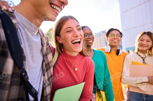 Preview: Laughing Caucasian female student with multiracial group of classmates posing hugging