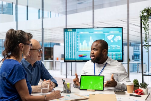 Preview: Financial advisor works with a green screen at table with his senior clients