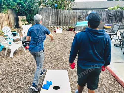 Preview: Friends playing cornhole or bags, in a backyard. tonythetigersson, Tony Andrews Photography