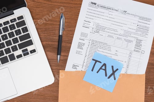 Preview: top view of tax form, laptop and blue card with 'tax' word at workplace