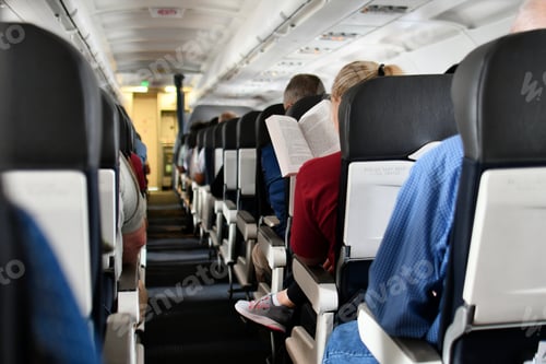 Preview: Passengers on an airplane enjoying a smooth flight while reading a book or napping as they travel