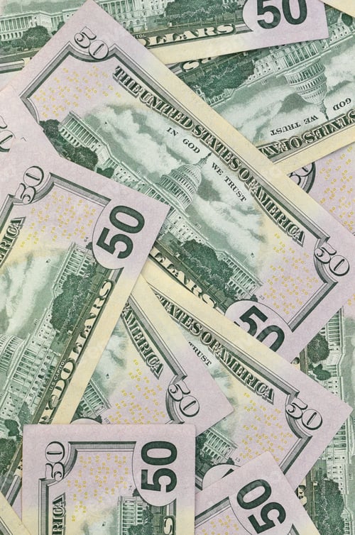 Preview: Many US fifty dollar bills on flat background surface close up