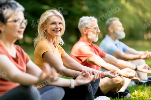 Preview: Beautiful Senior Woman Attending Group Yoga Class Outdoors,
