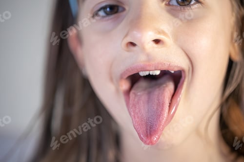Preview: A child girl open her mouth and show her tounge.