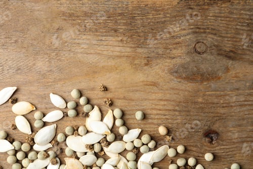 Preview: Mixed vegetable seeds on wooden background, flat lay. Space for text
