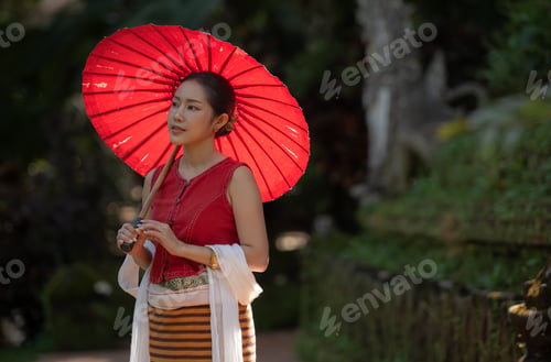Preview: Asian woman wearing traditional Thai dress holding a red umbrella