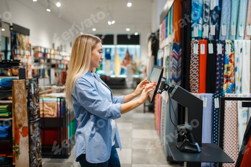 Preview: Saleswoman at cash register in textile store