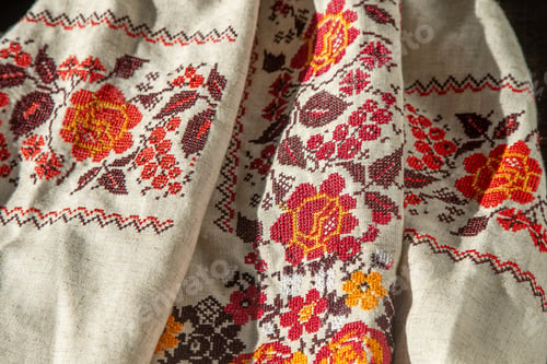 Preview: Ukrainian clothes embroidered shirt. Red orange and black threads background. Vyshyvanka is a symbol