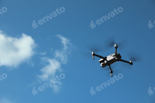 Preview: Modern drone with camera flying in sky on sunny day