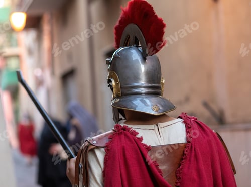 Preview: Roman centurion wearing helmet with red plume holding spear during a historical reenactment