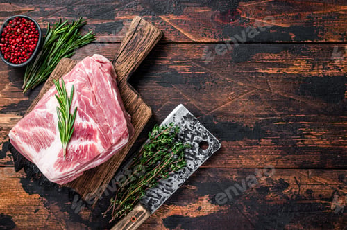Vista previa: Pork Shoulder raw meat for fresh steaks on wooden cutting board with butcher cleaver.