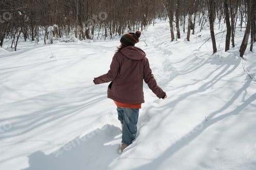 Preview: Smiling mid adult woman enjoys fresh air in winter snowy forest