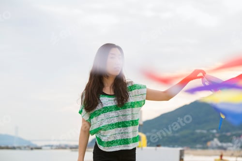 Preview: A woman on a beach in Kobe holding paper streamers.