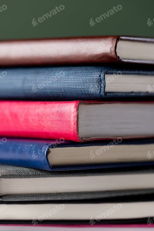 Preview: Close up of stack of books with copy space on green background