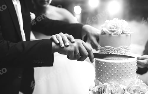 Preview: Black and white photo of couple hands cutting wedding cake. Wedding and celebration concept.