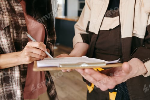 Preview: A person holding pen and signing paper after receiving plumbing service