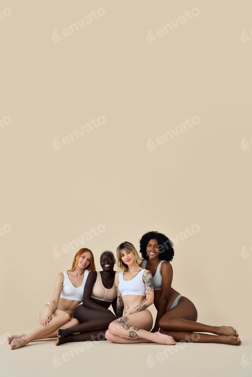 Preview: Happy diverse girls wear underwear sitting showing legs on background, vertical.