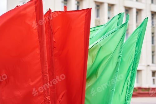 Preview: Red and green flags on a flagpoles flying in the wind