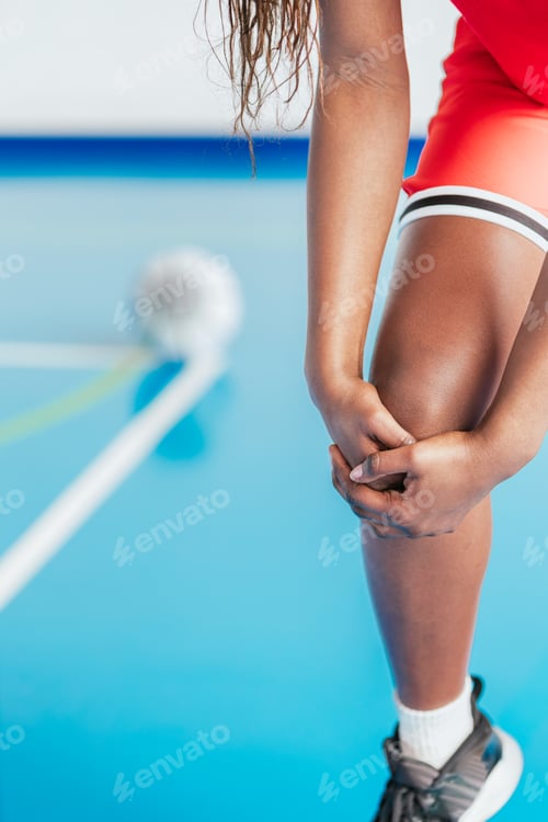 Preview: Female athlete suffering knee injury on indoor court