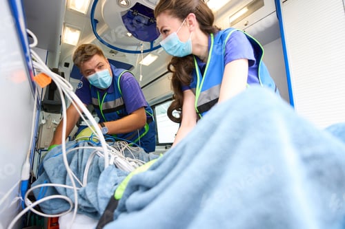 Preview: Paramedics secure a patient in an ambulance with seat belts
