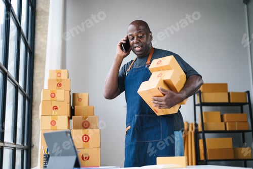 Preview: Small Business Owner Managing Orders in Warehouse, Talking on Phone, Holding Packages, Wearing Apron