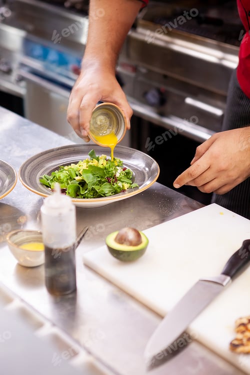 Preview: Chef seasoning salade with lemon juice