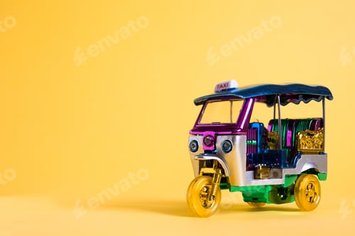 Preview: Model Toy tuk tuk isolated on yellow background. Thai traditional taxi in Bangkok Thailand. Souvenir
