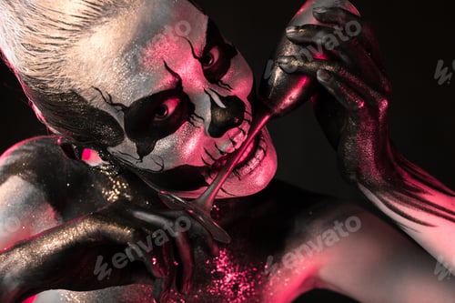 Preview: Pretty girl with skeleton makeup holds glass