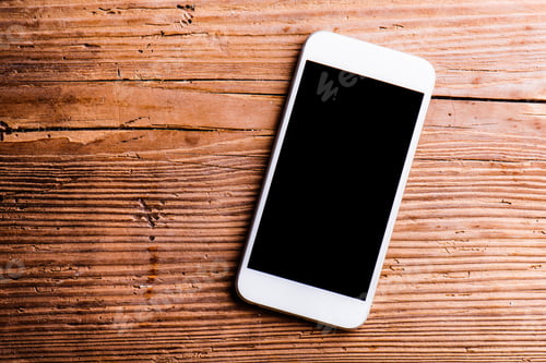 Preview: Smartphone laid on an old office desk, copy space