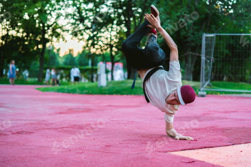 Preview: young hip hop street dancer in the city during the dusk doing freeze