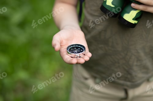 Preview: Caucasian cute kid boy with a backpack travels with a compass. Child boy scout holding in a hand