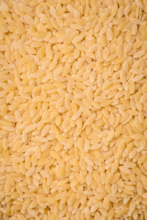 Preview: Raw risoni pasta made from durum wheat on a dark concrete background