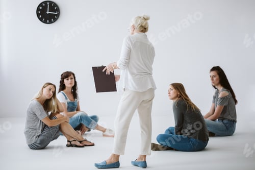 Preview: Senior psychotherapist writes the rules of group consultations for women on legal pad