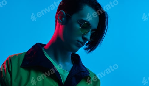 Preview: Fashionable young guy in studio with neon illumination